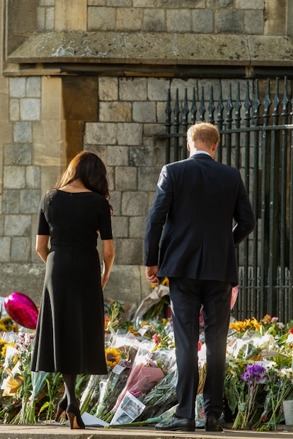 Prince Harry and Meghan, the Duke and Duchess of Sussex, view floral tributes to Queen Elizabeth II ...