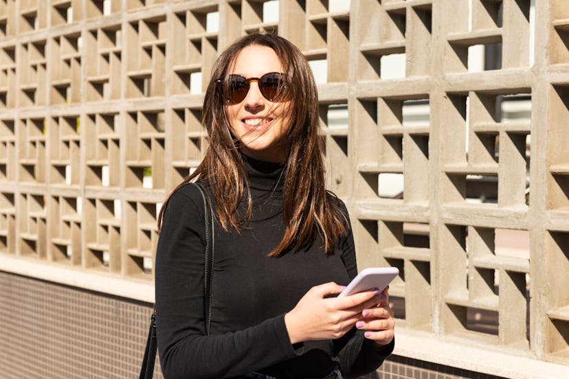 Image with a young woman in the city and using the technology