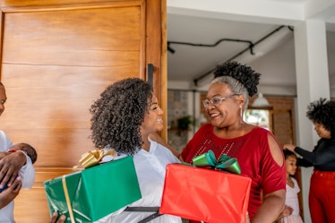 A woman gives a card with cute Merry Christmas wishes to her parents.