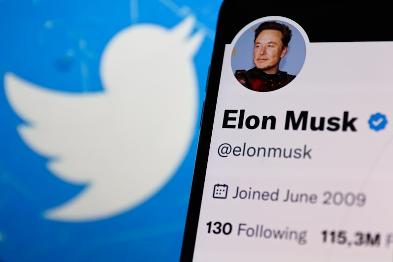 Elon Musk account on Twitter displayed on a phone screen and Twitter logo displayed on a laptop scre...