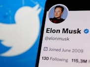 Elon Musk account on Twitter displayed on a phone screen and Twitter logo displayed on a laptop scre...