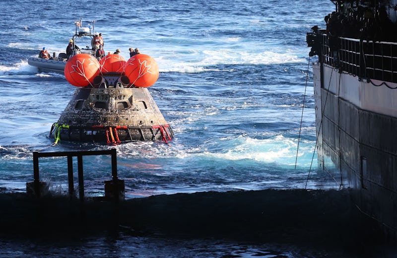 NASA's Orion Capsule is drawn to the well deck of the USS Portland during recovery operations after ...