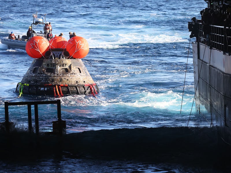NASA's Orion Capsule is drawn to the well deck of the USS Portland during recovery operations after ...