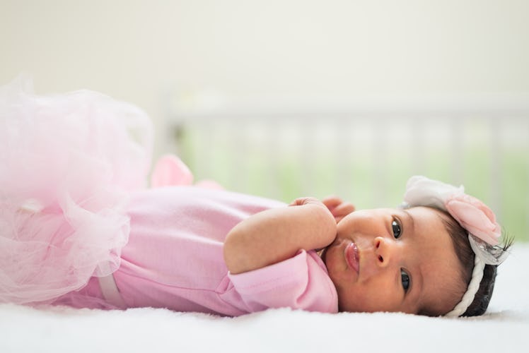 Close-up of a newborn baby girl lying down in the crib.