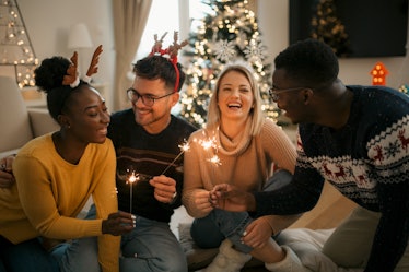 four friends enjoy sparklers during a holiday party, as they discuss which signs will have the most ...