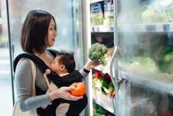 Young Asian mother doing grocery shopping with her baby in organic supermarket. Healthy and balanced...