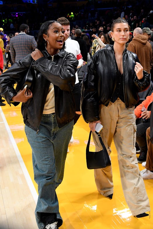 Hailey Bieber (R) and Justine Skye attend a basketball game.