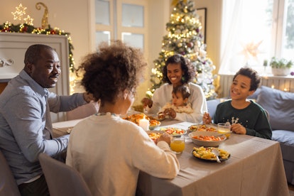 Family gathered around table for Christmas Eve dinner, in a story about Christmas Eve Instagram capt...