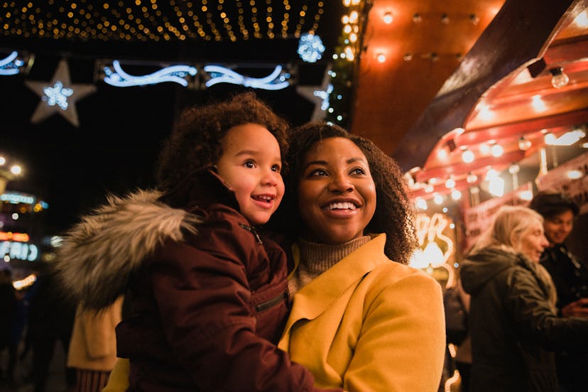 mother and daughter are both looking Christmas lights Christmas traditions