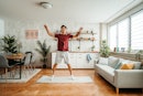 一个年轻英俊的中国男人在家里工作。做跳爆竹在家锻炼。