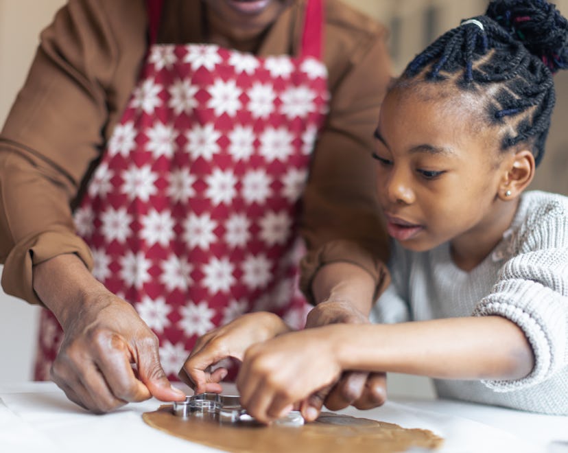 Grandmother making Christmas gingerbread cookies with her granddaughter, a Christmas tradition for f...