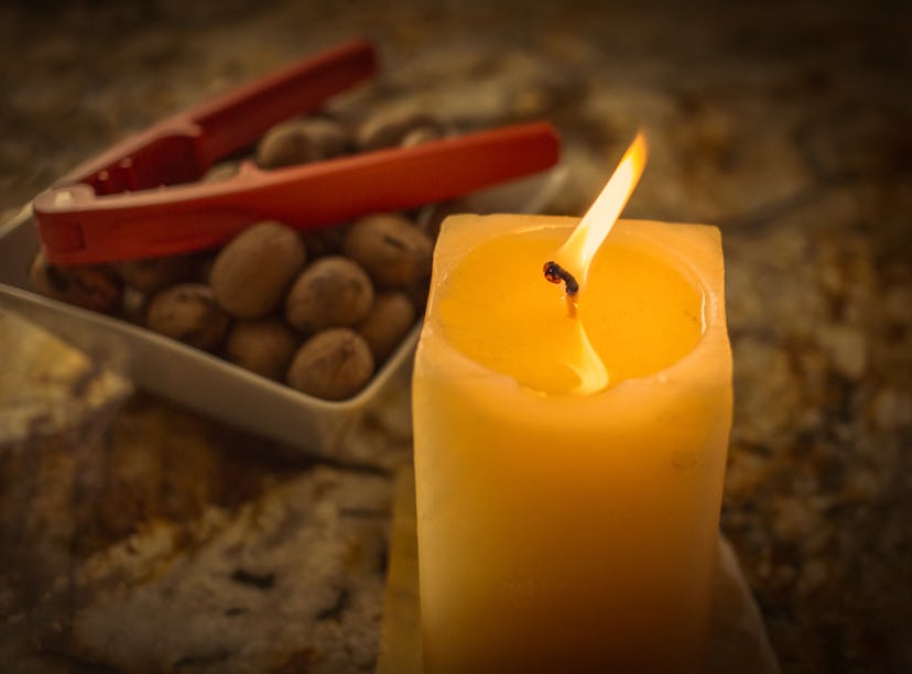 A butter candle from TikTok sits on a table next to some olives. 