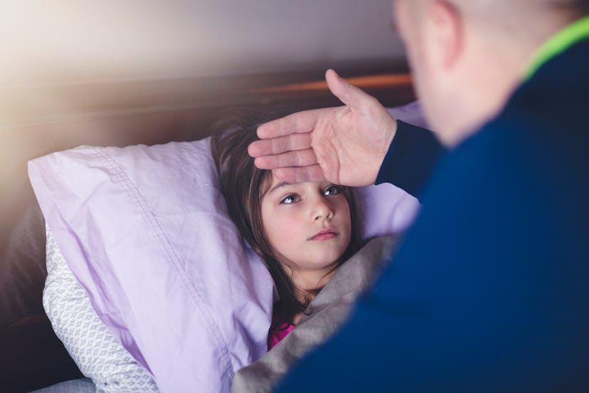 father checking daughter's forehead for flu, which can cause stomach pain in children