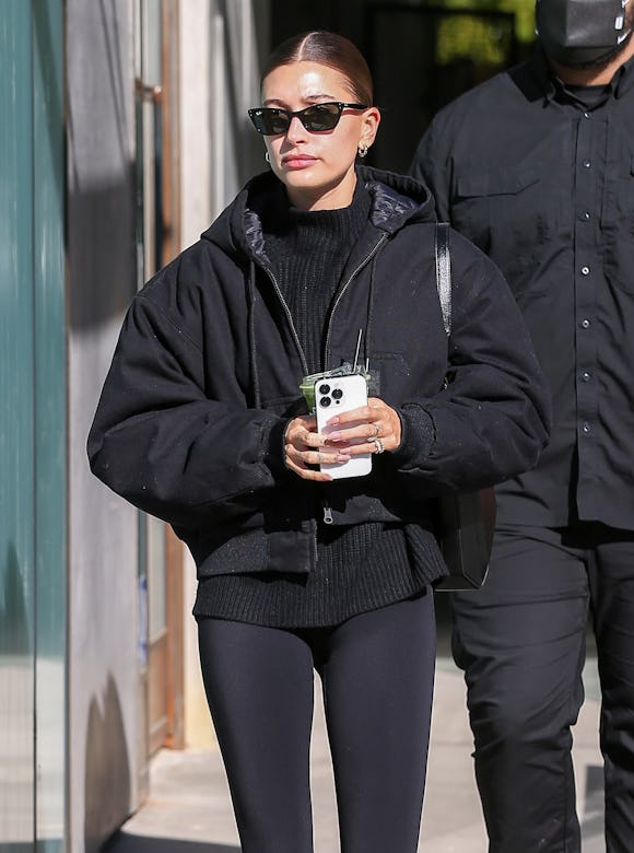 Hailey Bieber wearing a black puffer jacket.