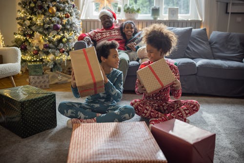 Family at home for Christmas opening gifts in a list of family christmas pajama captions