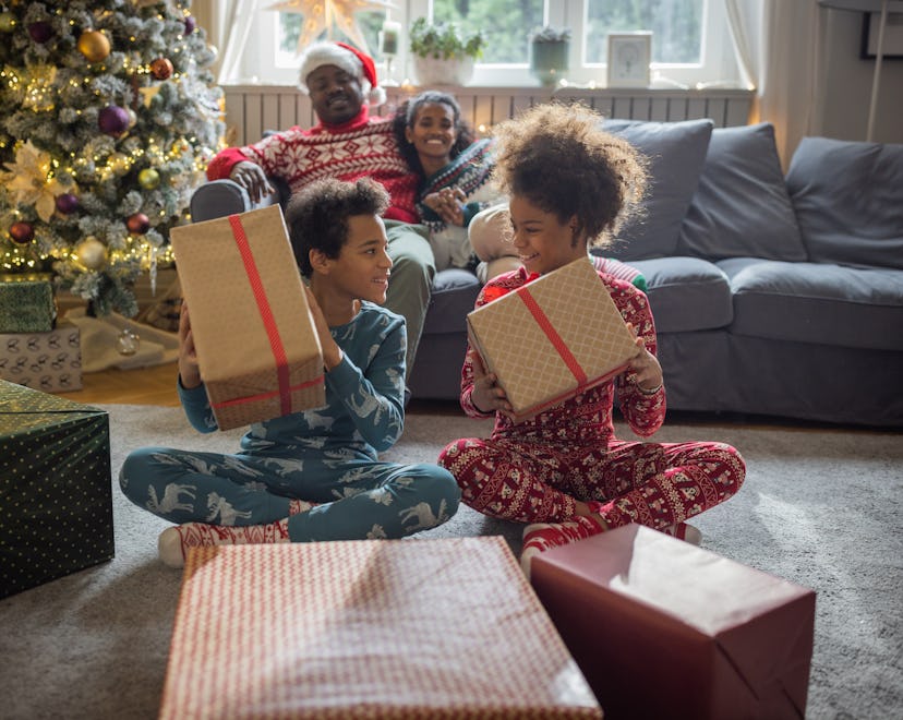 Family at home for Christmas opening gifts in a list of family christmas pajama captions