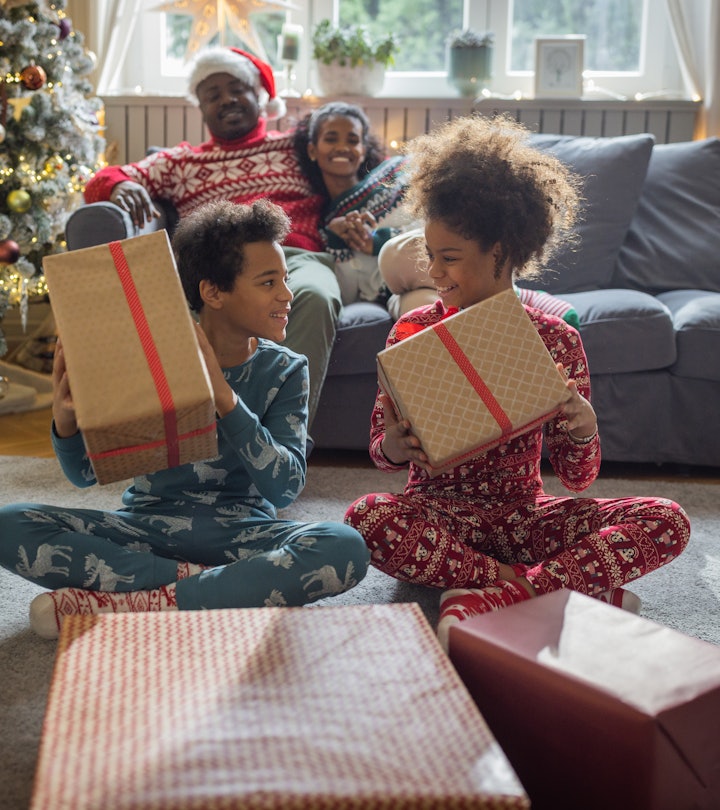 Family at home for Christmas opening gifts in a list of family christmas pajama captions