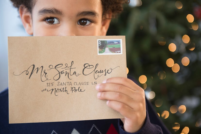 Little boy holds envelope addressed to Santa in story about Santa captions for Instagram posts.