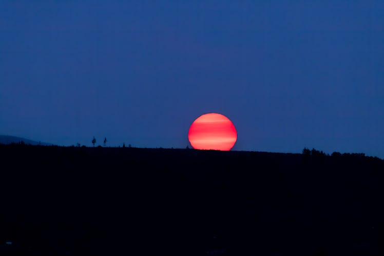 a picture of the moon setting over the horizon, as all of the planets station direct in the sky duri...