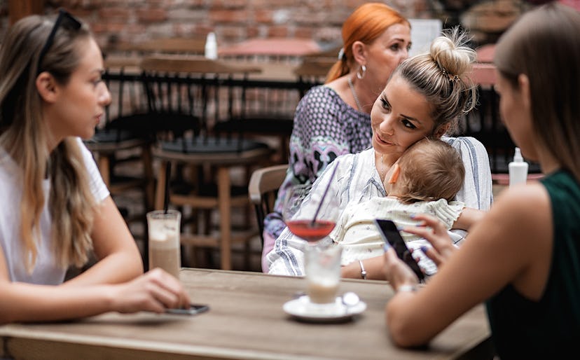 woman with baby at restaurant and probably wondering if its safe to be at a restaurant with a newbor...