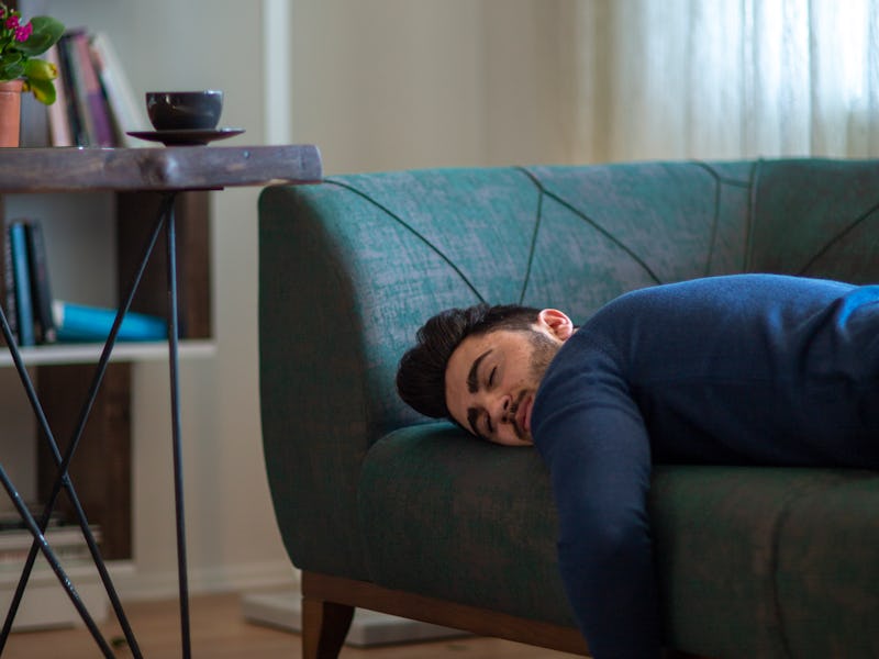 Exhausted man came home after work flopped down on sofa