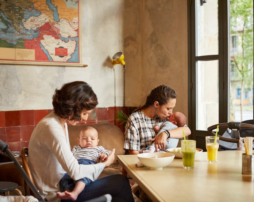 Happy mother with their babies sitting at table in restaurant When It's Safe To Bring Your Newborn T...