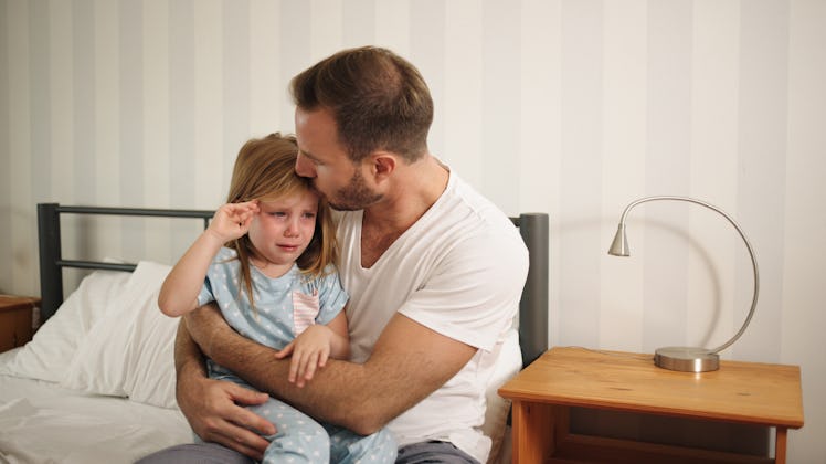 Father comforting his upset and sad daughter indoors