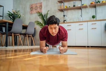 Young Asian man doing plank during workout at home
