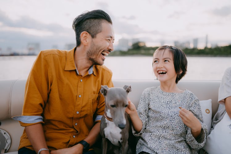Japanese father and young daughter having a good time on boat with dog, Tokyo Bay, Japan