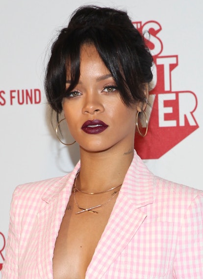 Rihanna in dark burgundy lipstick at MAC Viva Glam event 2014 with long bangs and pink blazer