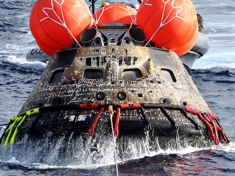 AT SEA, PACIFIC OCEAN - DECEMBER 11: NASA's Orion Capsule is drawn to the well deck of the U.S.S. Po...