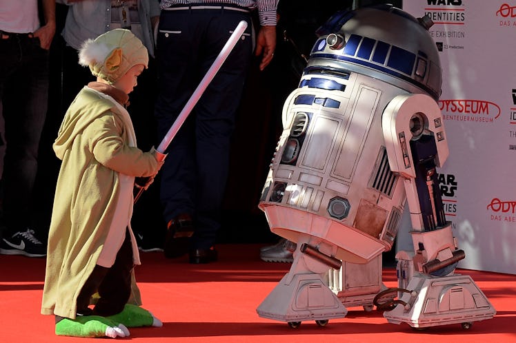 COLOGNE, GERMANY - MAY 20: A little boy dressed as Grand Master Yoda meets the R2-D2 model on the r...