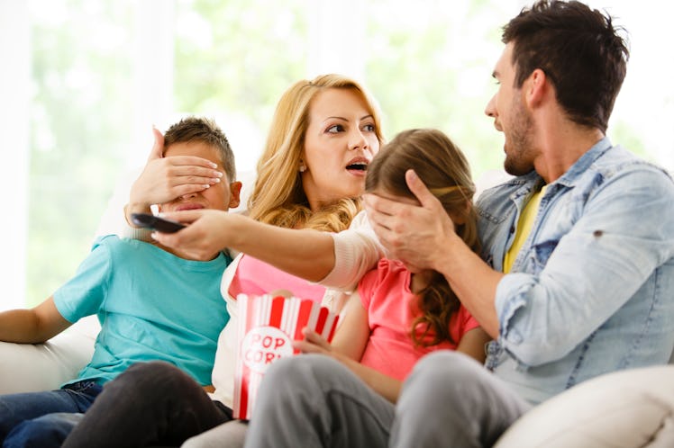 Parents cover their children's eyes while watching TV