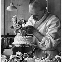 A confectioner at a Knightsbridge store pipes the finishing touches onto cakes which will be in the ...