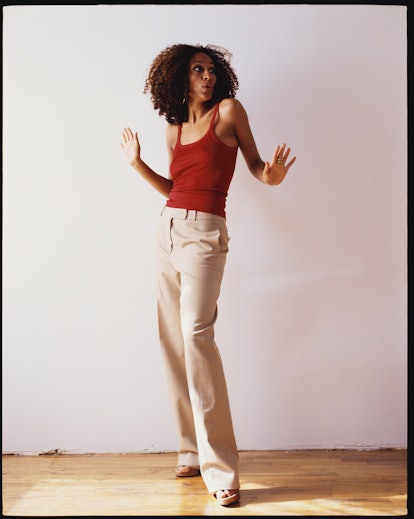 Tracee Ellis Ross wearing a red tank top and beige pants in the '90s.