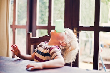 Little boy drinking his milk from a beaker without using his hands