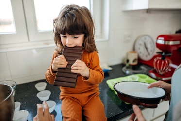 一个孩子正在咬一块巨大的巧克力棒。