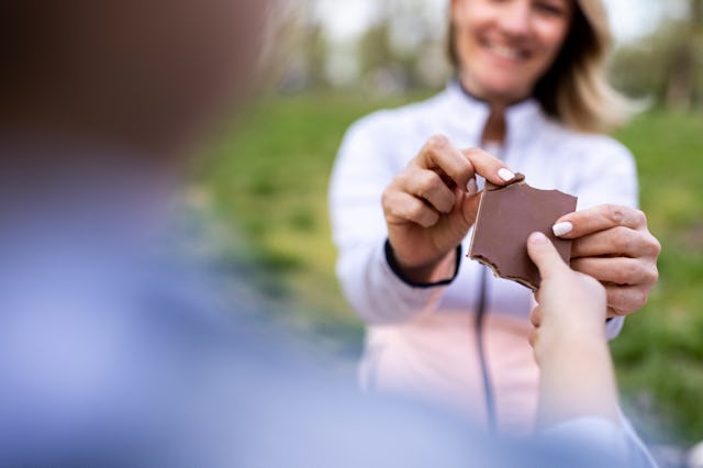 A kid and mother share a chocolate bar. Consumer Reports has warned pregnant people and kids against...
