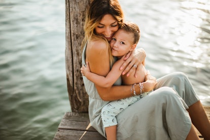 Mother and toddler son hugging on pier, in a story about baby name trends for 2023.