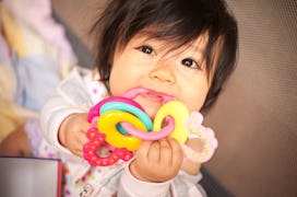 a baby chewing on a teether in an article about teething fever