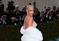 Kim Kardashian platinum hair in bun and Marilyn Monroe dress on the steps of The 2022 Met Gala Celeb...
