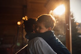 Photo of young mother bonding with her son in a log cabin during winter holidays