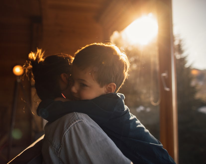 Photo of young mother bonding with her son in a log cabin during winter holidays