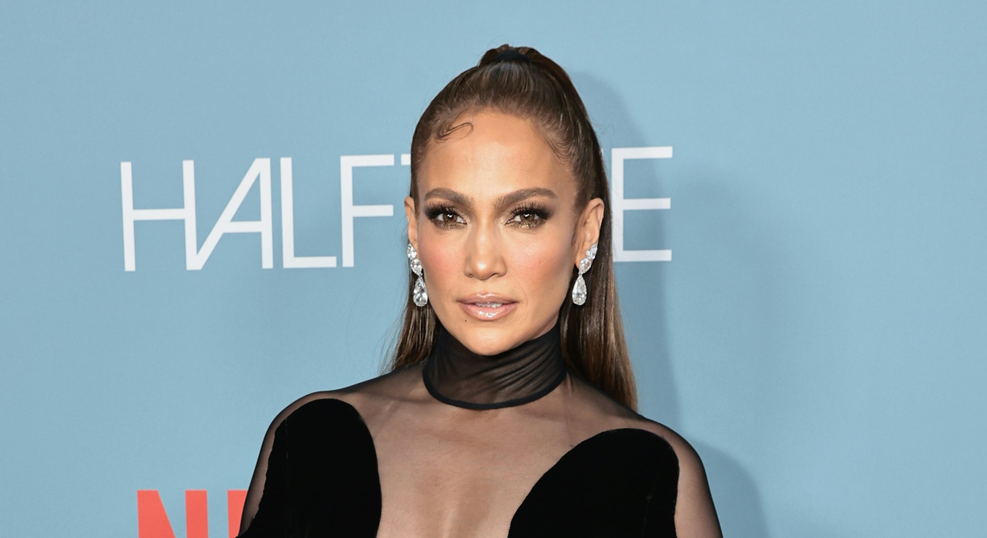 Jennifer Lopez attends "Halftime" Premiere at the Tribeca Festival 2022 in a black, mesh cut-out dre...