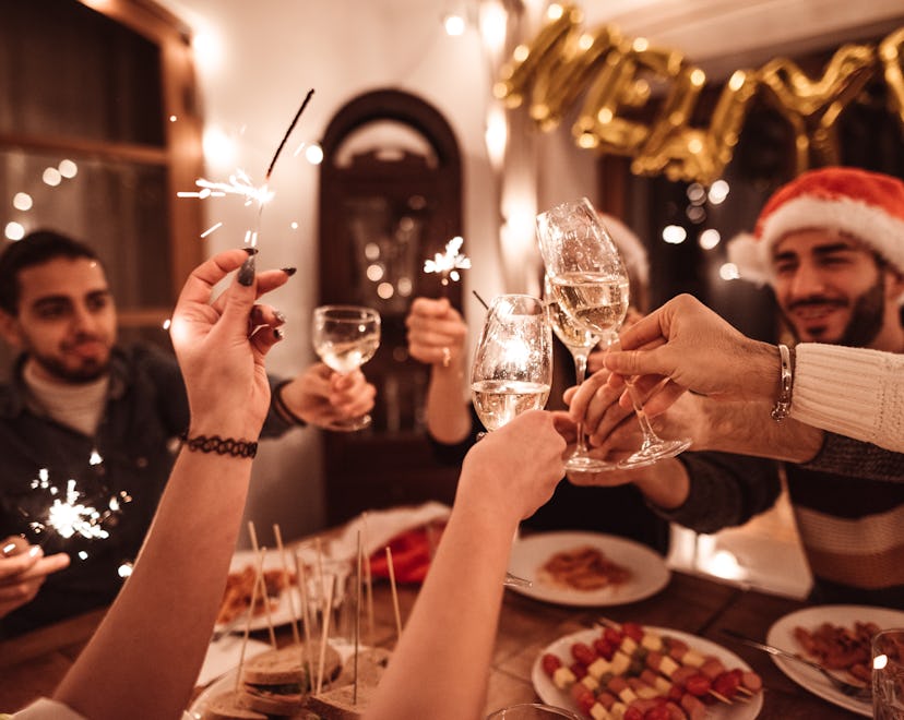 A group of friends toasts at dinner, in a story about new year's trivia questions and answers.