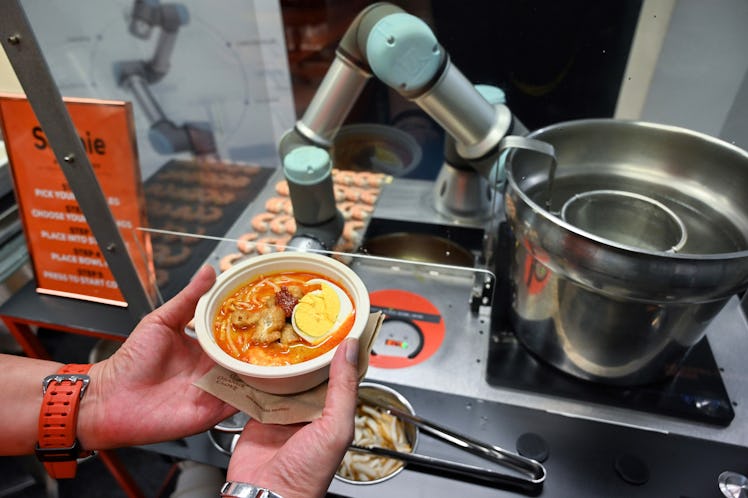 This picture taken on July 26, 2019 shows a person holding a bowl of laksa, a local dish of rice noo...