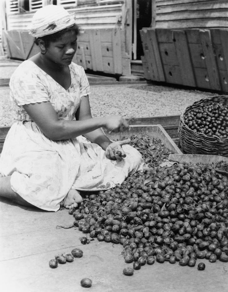 Grenada, Removing nutmeg husksA Grenadian woman removes husks from a mound of harvested nutmeg seeds...