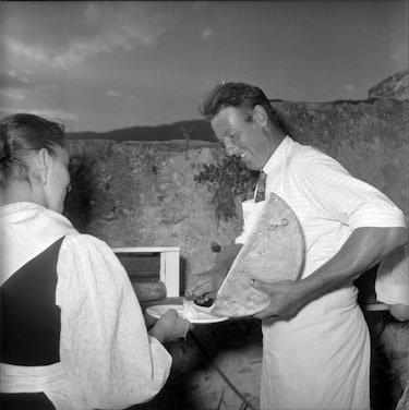 Man serving raclette, Sion 1959   (Photo by RDB/ullstein bild via Getty Images)