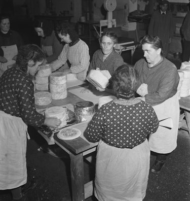 Female cheesemongers packaging block of cheeses at a market, London, UK, circa 1948. (Photo by Bob S...