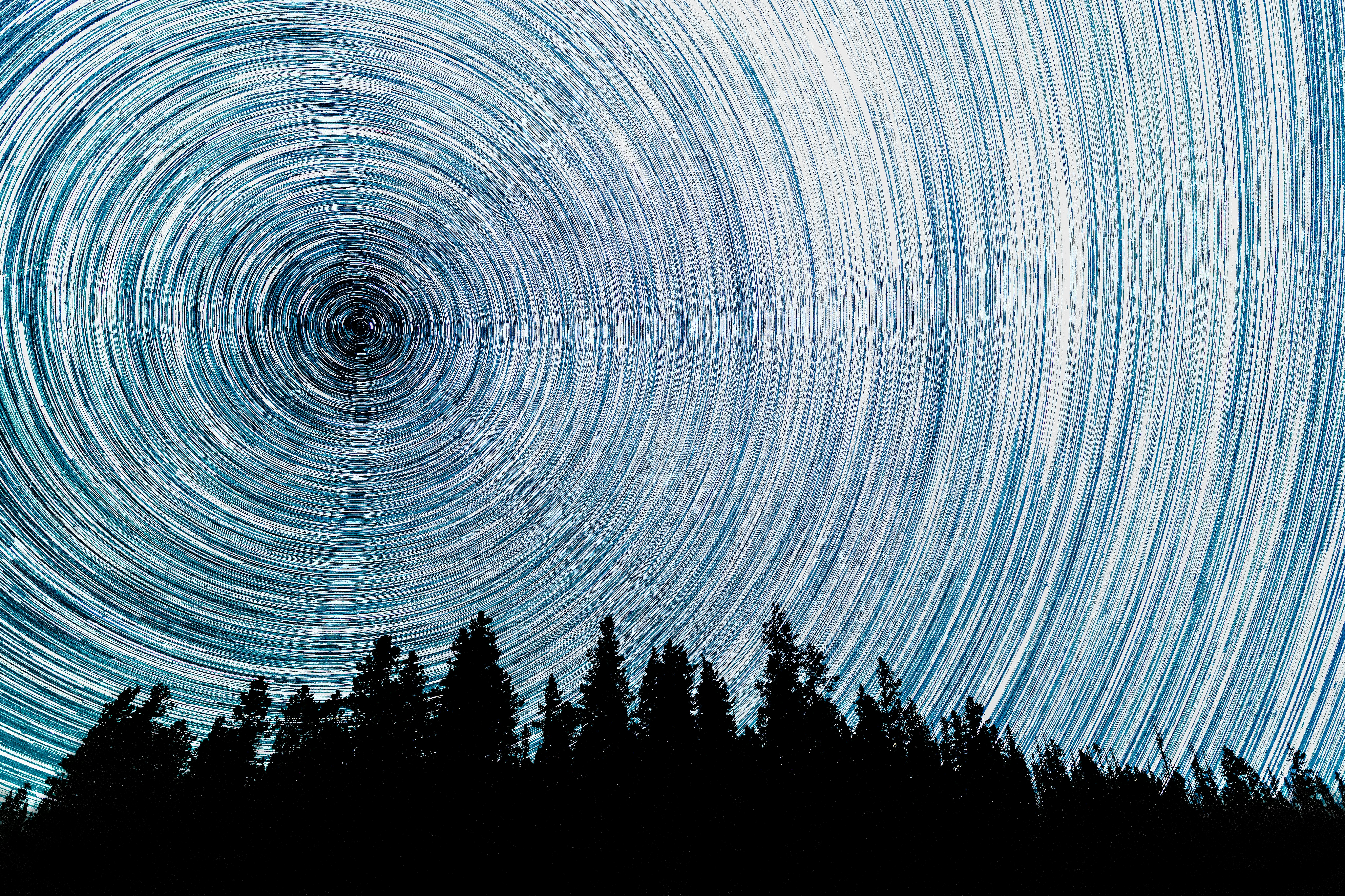 Abundant stars fill the sky on a dark night as meteors from the Perseid Meteor Shower blaze across t...